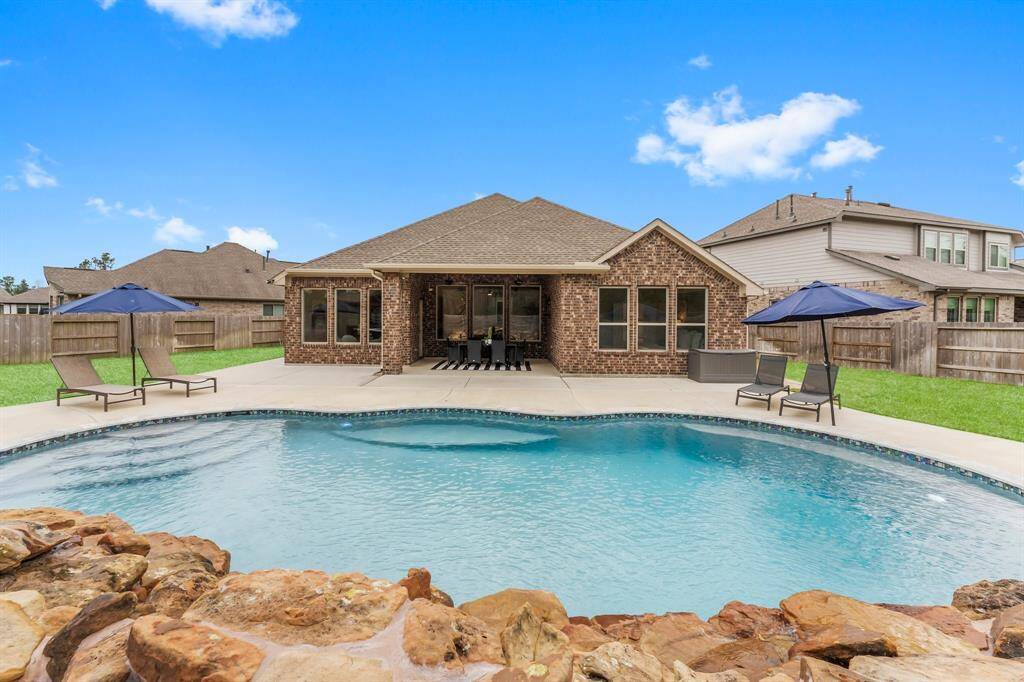 Spacious covered patio with brick exterior, large windows, and ceiling fans for added comfort.