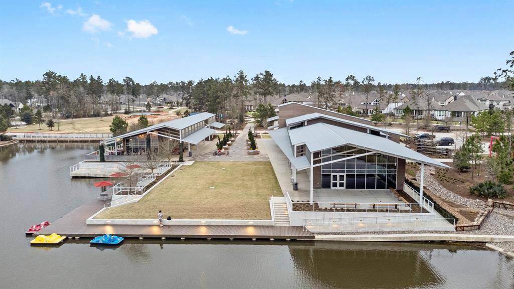 This aerial view showcases a spacious property with a charming home featuring a backyard pool. The house is centrally located, with a fenced yard providing privacy. Ideal for families or entertaining, the outdoor area includes a patio space and mature trees nearby.