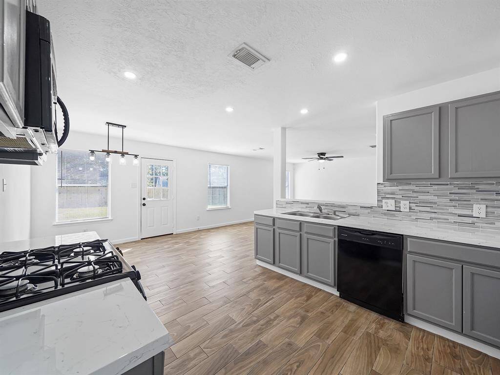 This spacious culinary haven features an abundance of cabinet and counter space, perfect for all your cooking and entertaining needs. The newly installed modern recessed lighting creates a warm and inviting atmosphere, enhancing the sleek aesthetic of the room.