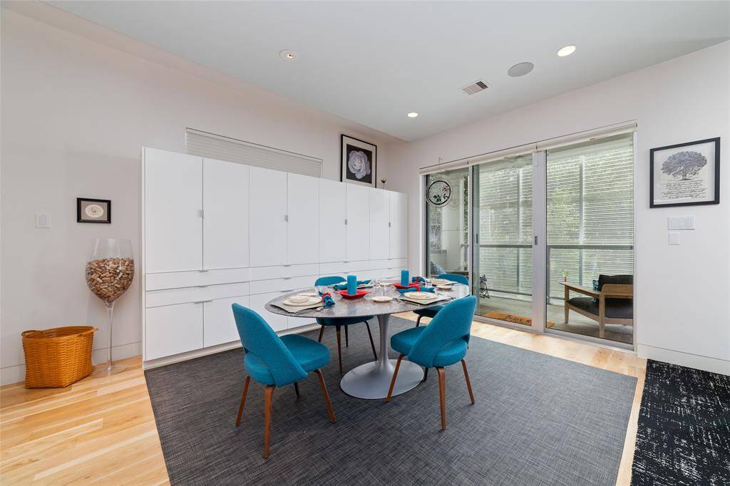 The dining room features a custom-built wall of cabinets and drawers, providing exceptional storage. A sliding glass door opens onto a private covered porch, perfect for enjoying the evening and the colorful LED screen.