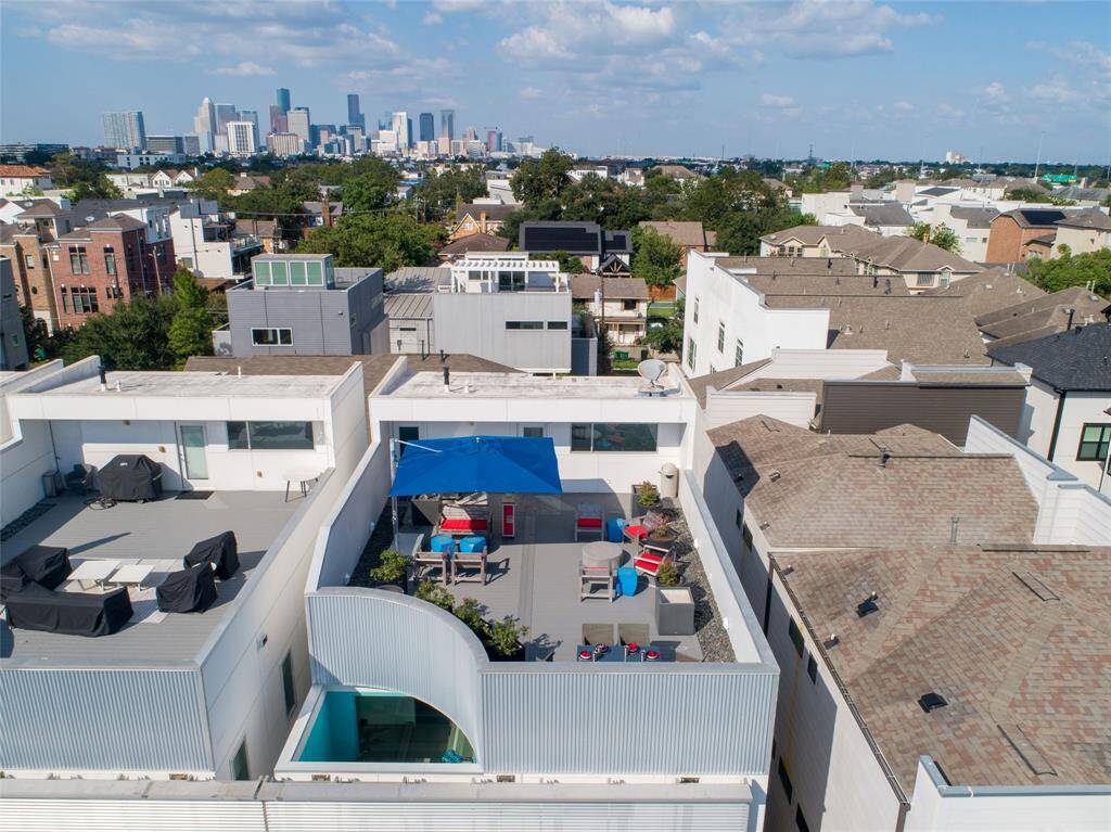 The 4th level features a Trex deck, prepped with electrical wiring for hot tub installation. The deck includes a hose tap, a gas grill connected to the home, and a 36" Paloform fire pit. The mechanical room houses a Rinnai tankless water heater and two furnaces, with additional storage space.
