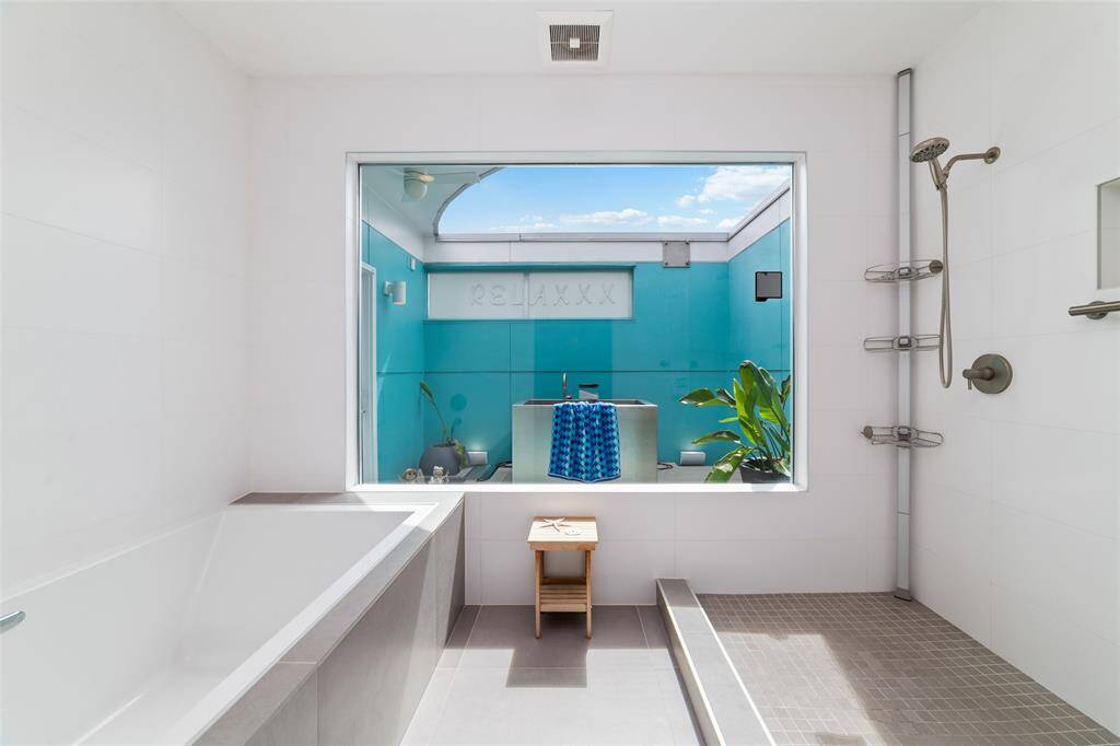 Step into the Award-Winning primary bathroom boasting a wet room with dual shower heads, handheld sprayers, and an oversized, luxurious 6-foot-deep bathtub that must be seen to be believed.