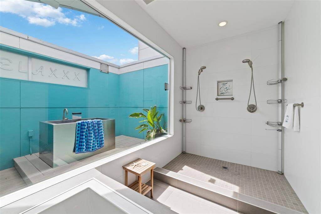 Step outside the primary suite to find a serene Japanese soaking tub, perfectly situated on the deck for ultimate relaxation and tranquility. It's the perfect spot to relax, tend to your plants, or enjoy the weather. The deck door has a side-rolling screen to let in cool evening breezes.