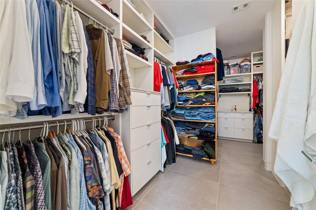 Two spacious walk-in closets with floor to ceiling shelves and cabinet drawers provide plenty of storage, completing this dream ensuite.