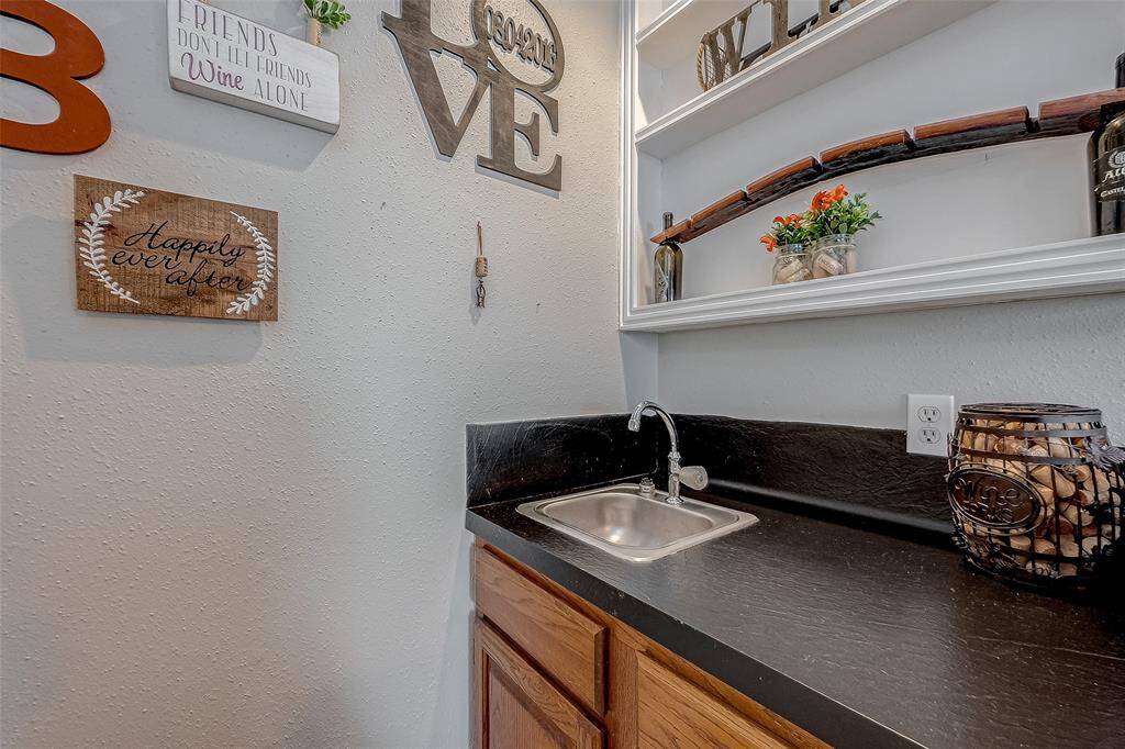 A wet bar with working sink perfect for hosting and entertaining. There is a large storage closet here too!