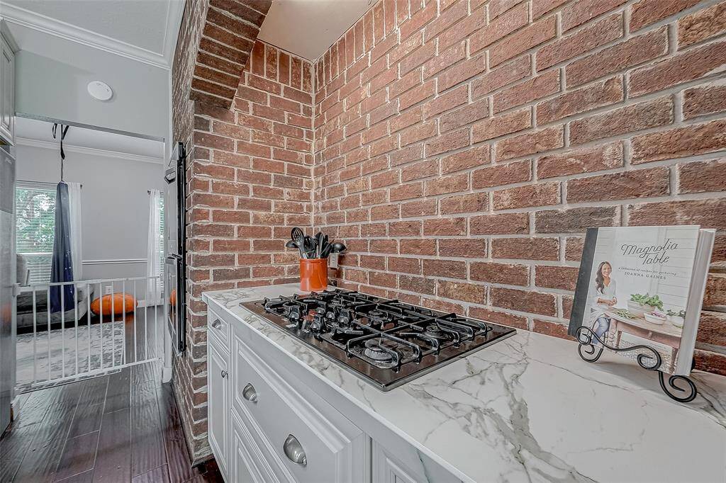 This unique brick feature surrounds the gas cooktop and provides pull out drawers for storage. The Dekton countertops are fire & heat resistant.