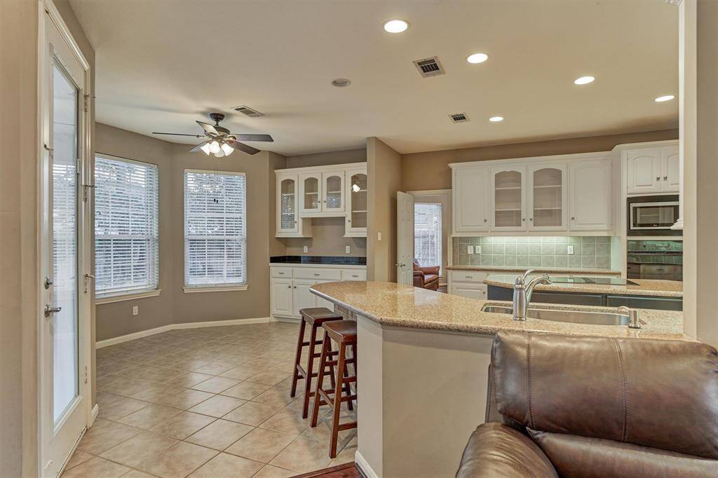 Tile flooring, loads of cabinetry for storage and counter seating are just a few great features of this incredible kitchen.