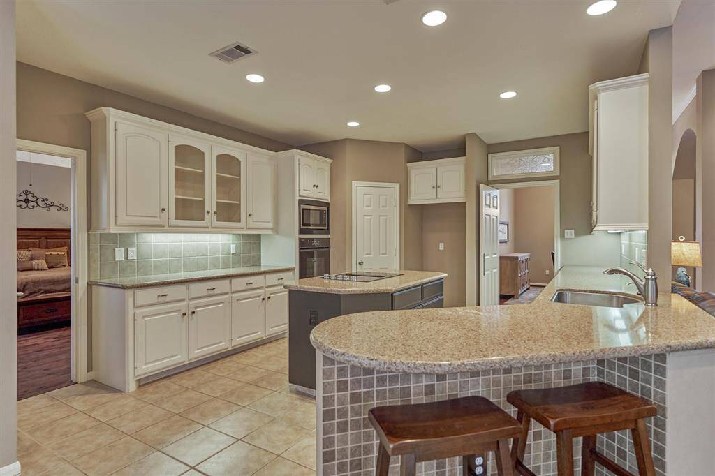 This gourmet kitchen boasts of gleaming granite countertops offering multiple prepping and serving areas for family gatherings.