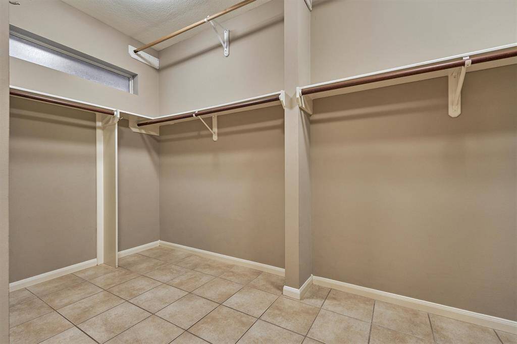 Massive primary closet with convenient upper rods for rotating seasonal wear.
