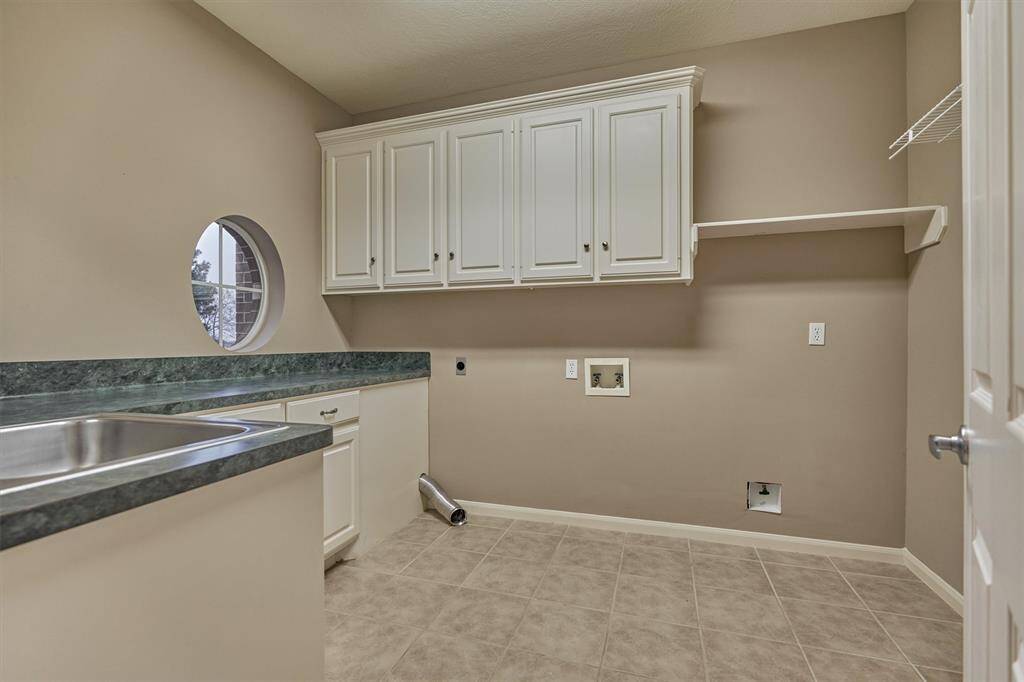 Spacious laundry room with storage and convenient counter for sorting and folding clothes.