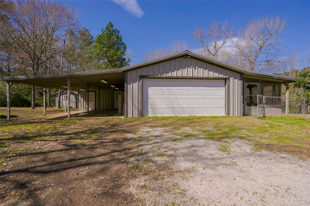 Storage building in the back with a carport