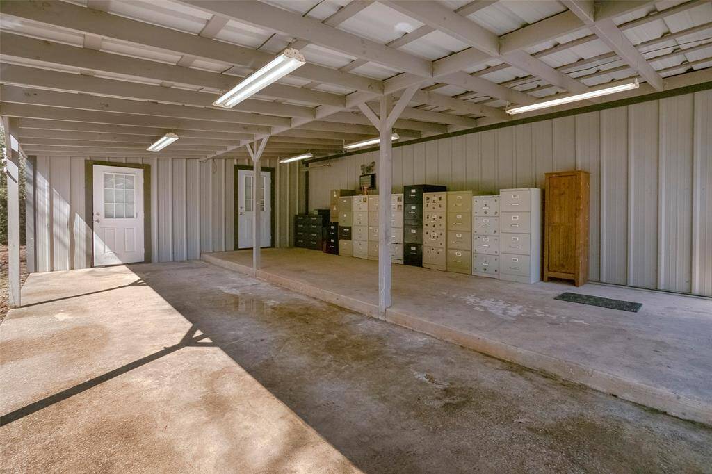 Under the carport with entrance into additional storage areas