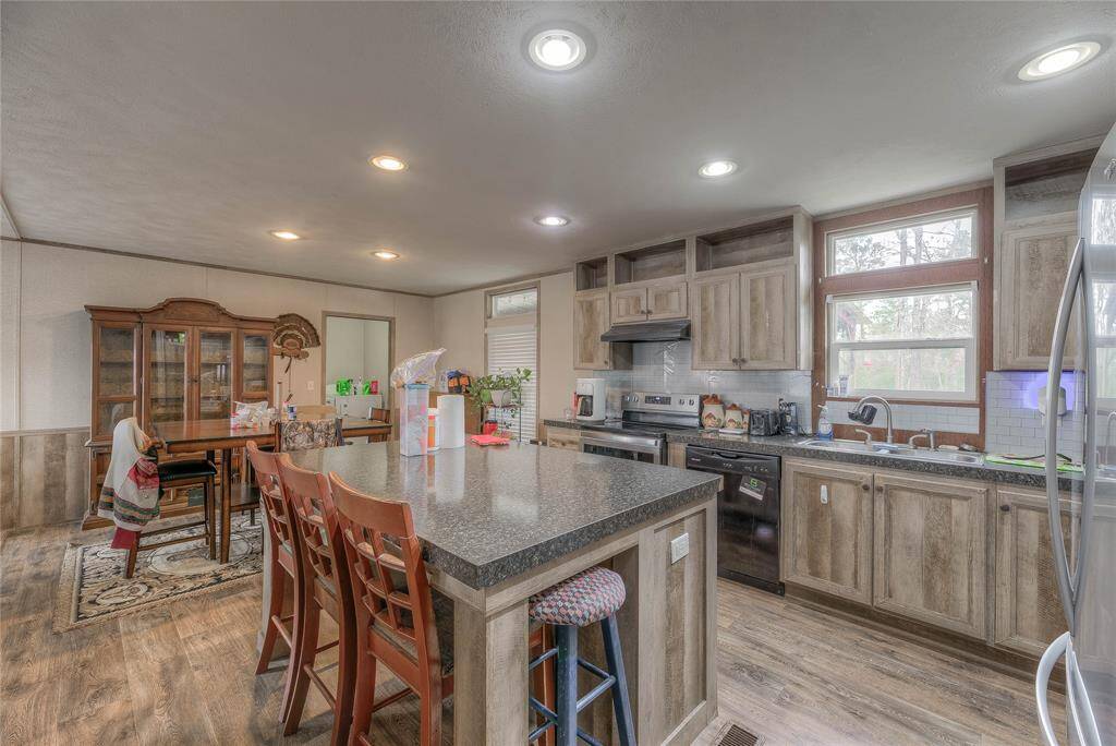 The kitchen has an island that can seat at least three people. There is also an open area for the dining and living areas.