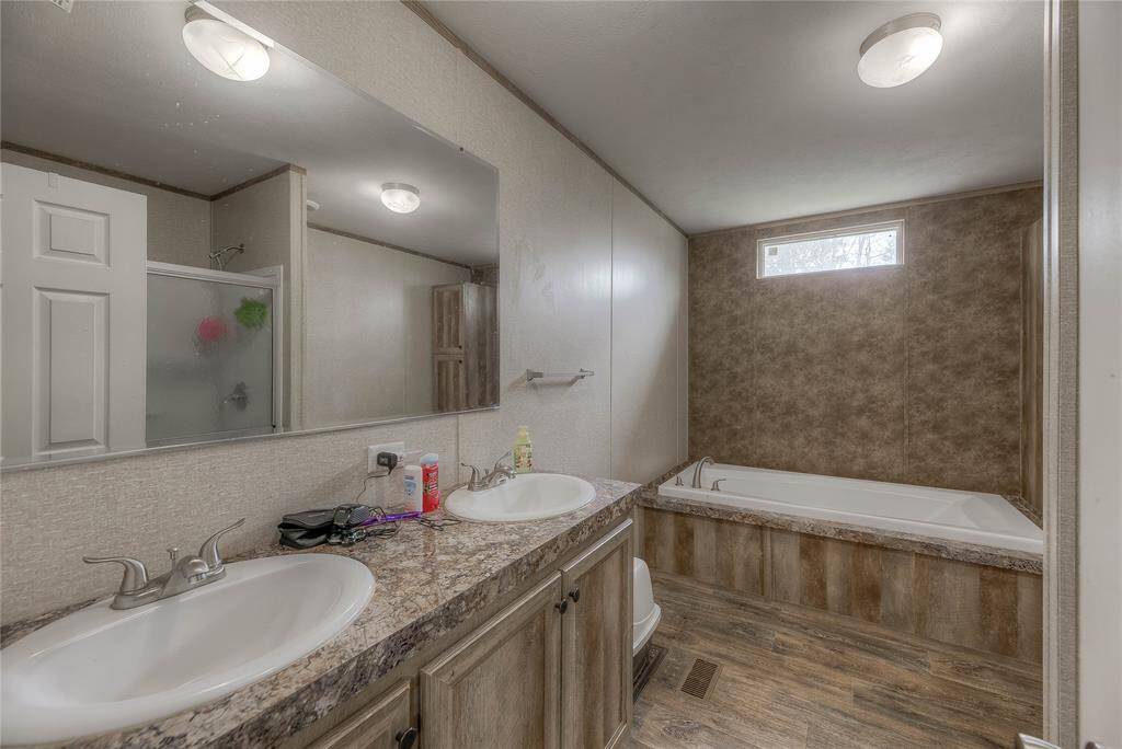 The bathroom located in the main bedroom features double sink and a big tub.