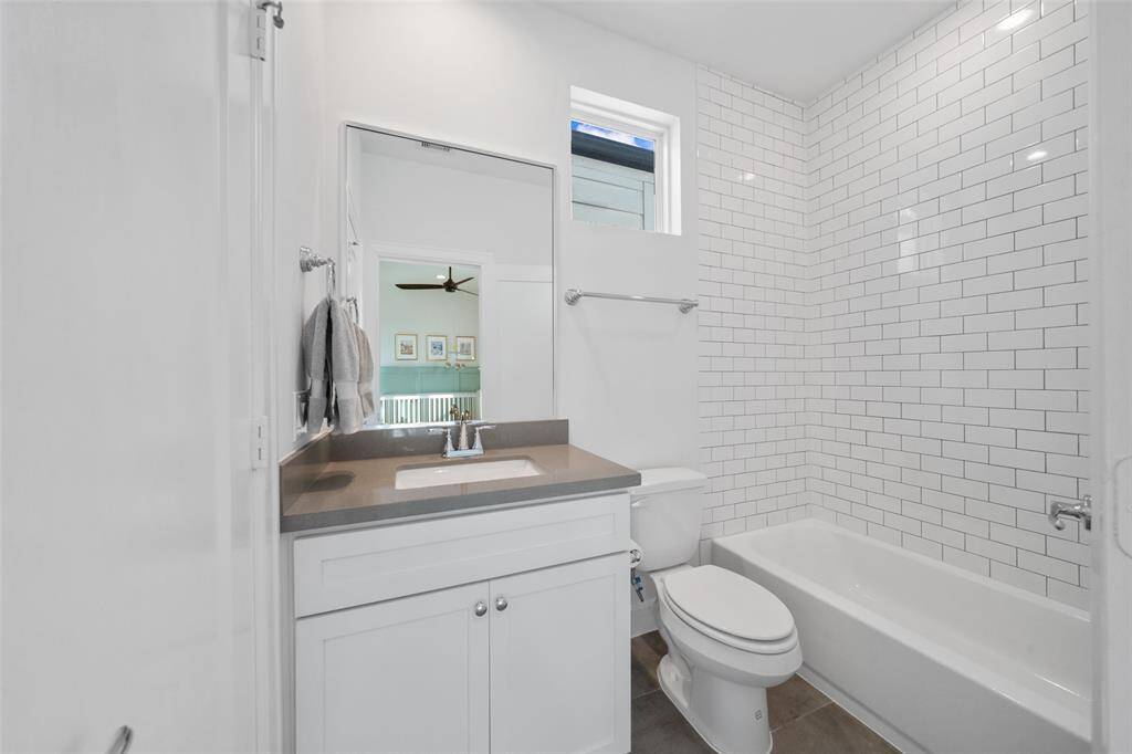 Secondary bathroom, featuring wall to ceiling subway tile and shower/tub combo.