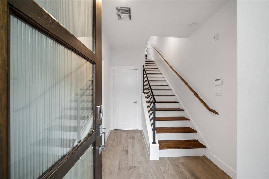 Inside entry, featuring sleek entry, iron rail stair and natural light