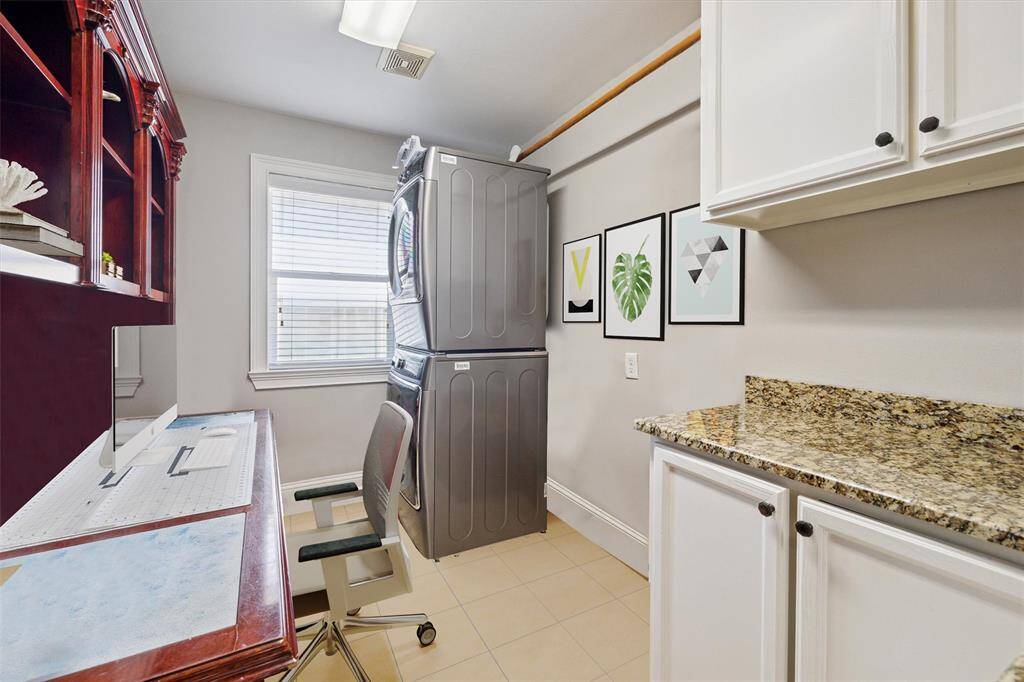 This versatile laundry and workspace is conveniently situated on the first floor, where all bedrooms are located, making it easy to handle household tasks without going upstairs. The built-in desk area offers a dedicated spot for work, crafts, or managing household paperwork. A large window brings in natural light, creating a bright and functional environment that helps streamline daily routines.