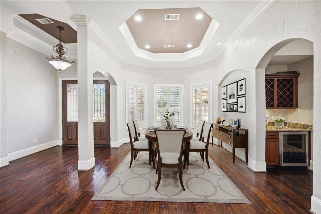 Host unforgettable dinner gatherings in this elegantly designed formal dining room, featuring soft recessed lighting, beautiful bay windows with classic shutters, and a sophisticated ambiance. (Digitally Staged)