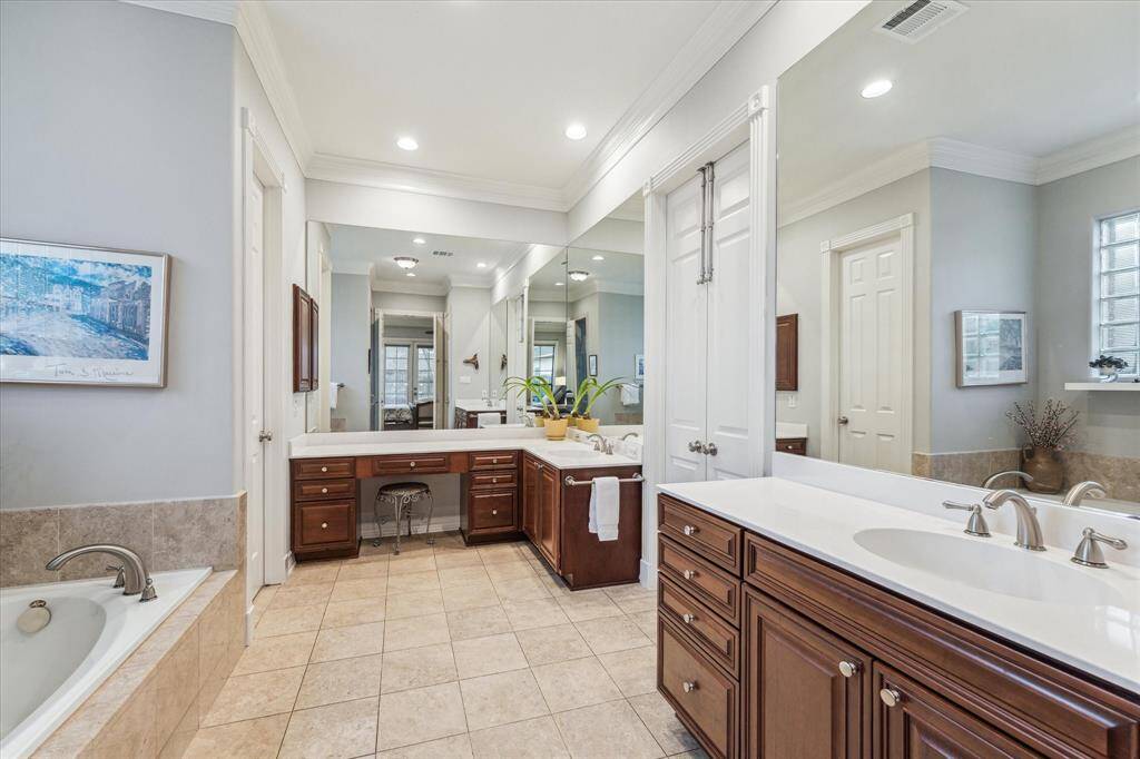 This spacious primary bathroom features dual vanities with large linen closet. It is the perfect place to get away and soak til your heart's content.