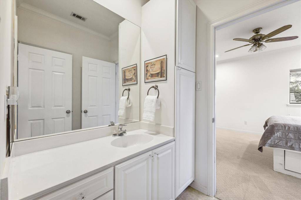 This is a clean and bright Jack & Jill bathroom with a large vanity and white cabinetry.