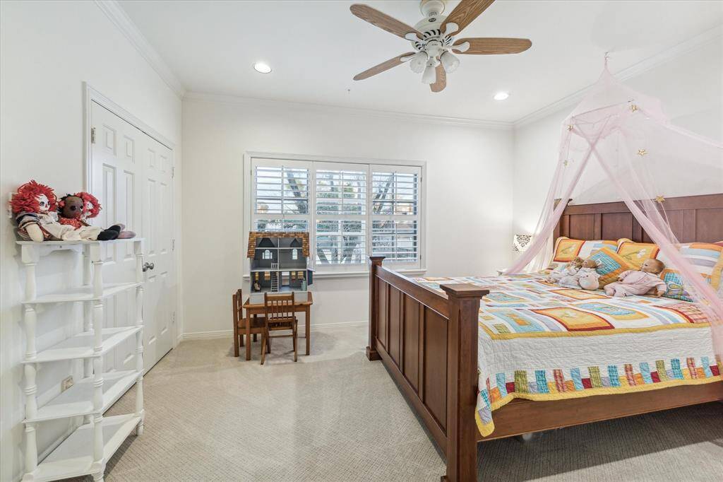 This is a secondary bedroom featuring a large window with plantation shutters and two large closets.  Night time gives you a beautiful City view of lights.