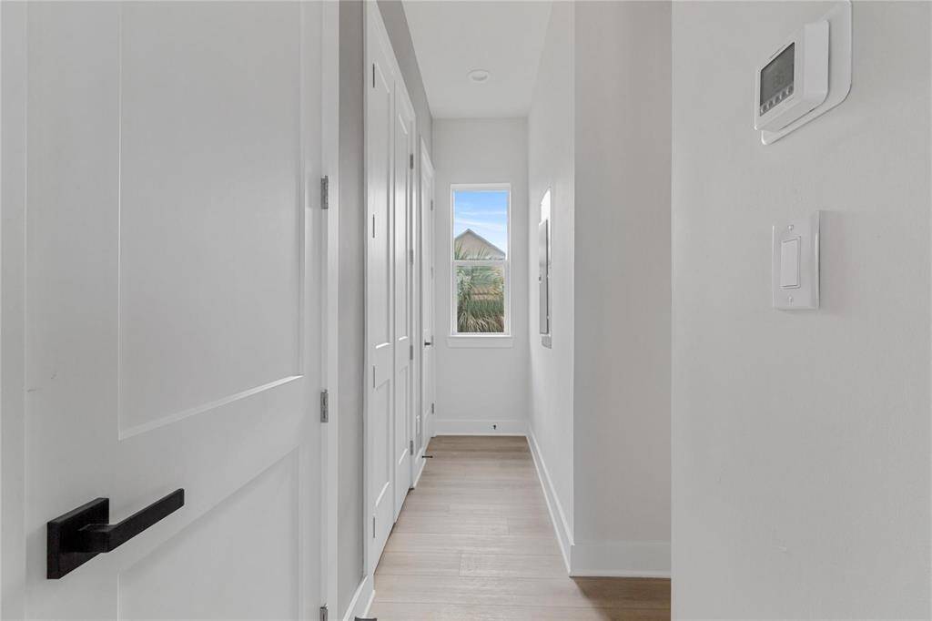Hallway containing the half bathroom, laundry room, secondary bedroom, and storage/closet space.