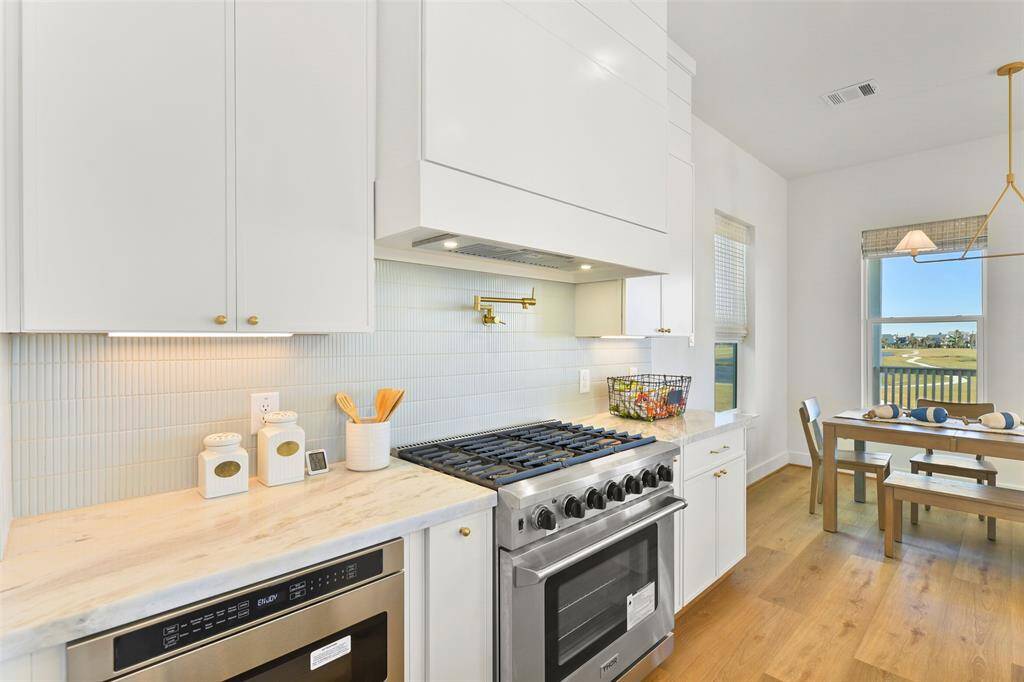 This kitchen is thoughtfully designed with soft-closing cabinets and drawers, under-cabinet lighting, a convenient microwave drawer, and a brushed-gold pot filler—luxurious details that make it a dream space for the chef in your life.