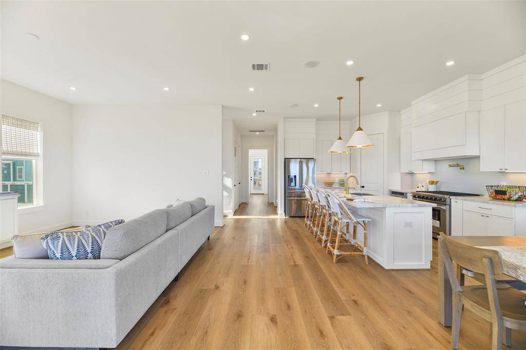 The heart of the main floor, showcases the seamless flow between the living, dining, and kitchen spaces. Filled with natural light and designed for both comfort and entertaining, this space is perfect for creating cherished memories with family and friends—all while enjoying breathtaking water views from every angle.