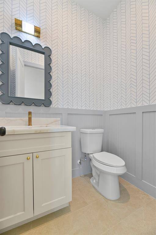 The main floor half bath offers both convenience and style, featuring elegant wainscoting and sophisticated designer finishes that elevate the space.