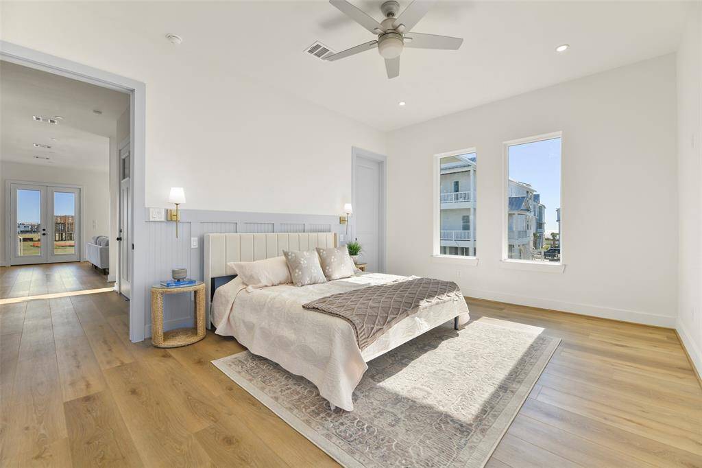 Step into the main floor primary bedroom, a serene haven featuring custom wainscoting, expansive pane-less windows, and designer paint finishes that exude comfort and sophistication.