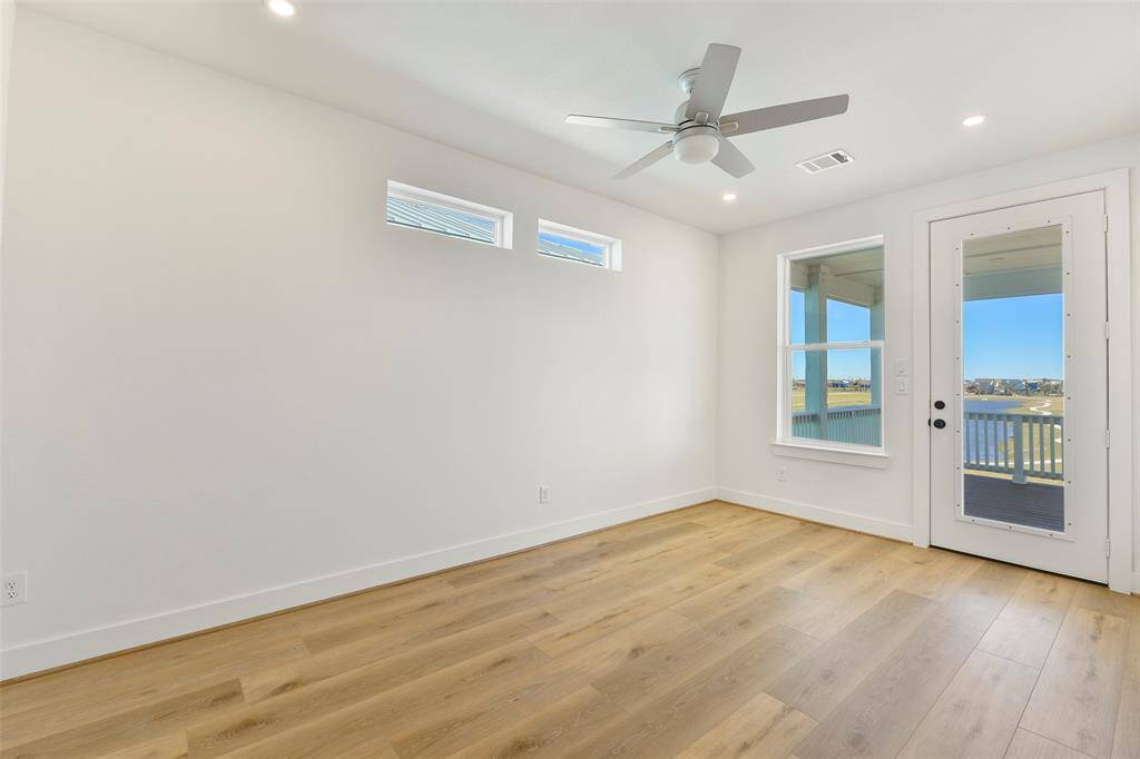Experience stunning water views from this top-floor bedroom, with direct access to the expansive deck—perfect for soaking in the coastal scenery.