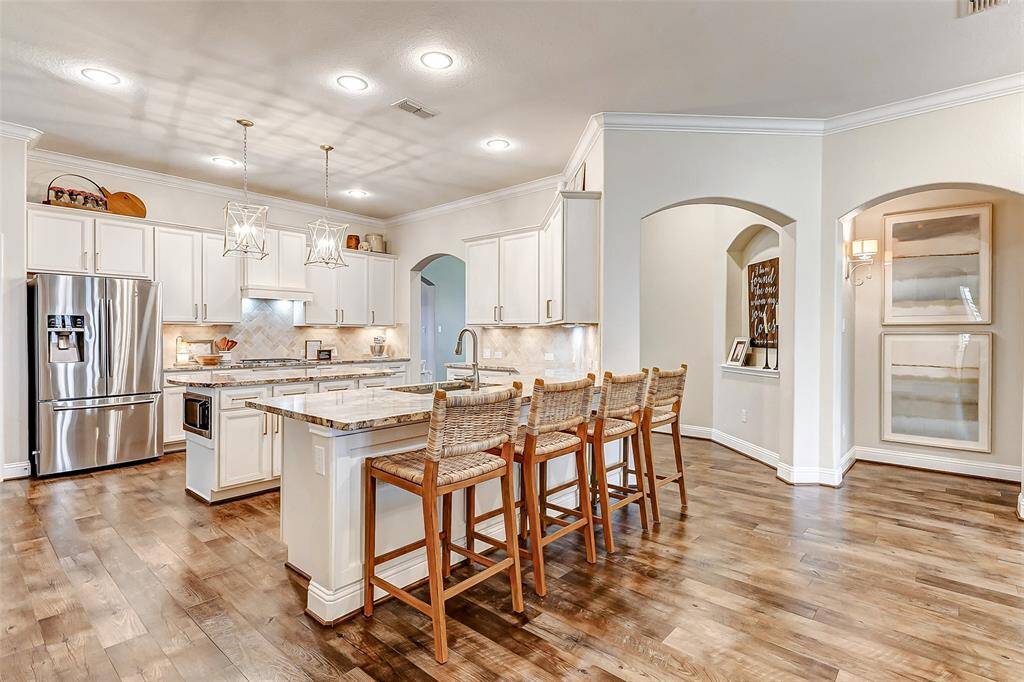 The spacious breakfast bar comfortably accommodates several bar stools, offering a convenient dining option and a perfect spot to sit and chat, all while staying connected to the action in the kitchen.