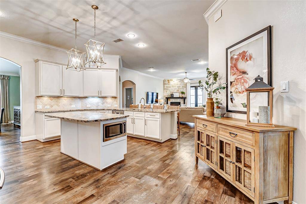 Additional features include a built-in microwave conveniently located on the island. Nearby, you'll find a spacious wall, ideal for showcasing your china cabinet or other treasured pieces.