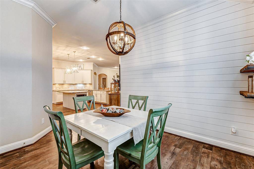 Additional features include luxury vinyl plank floors, crown molding, soaring ceilings, and a beautiful lighting fixture that enhances the room's elegance.