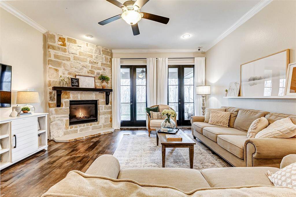 Welcome to your expansive family room! Highlights include a striking stone fireplace that extends up to the ceiling and double modern French doors, installed in 2022, that open to your backyard oasis.