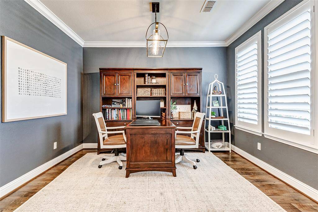 Just off the entryway, you'll find your incredible home study! Highlights include accent paint, designer lighting, and elegant crown molding. Your eyes will be drawn to the windows adorned with plantation shutters, offering picturesque views of the front yard.