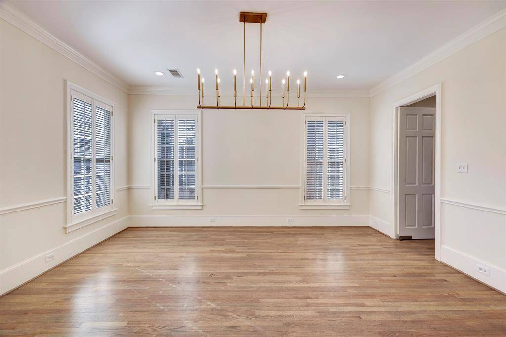 Formal Dining Room with an abundance of natural light. Room is centered by an elegant fixture.