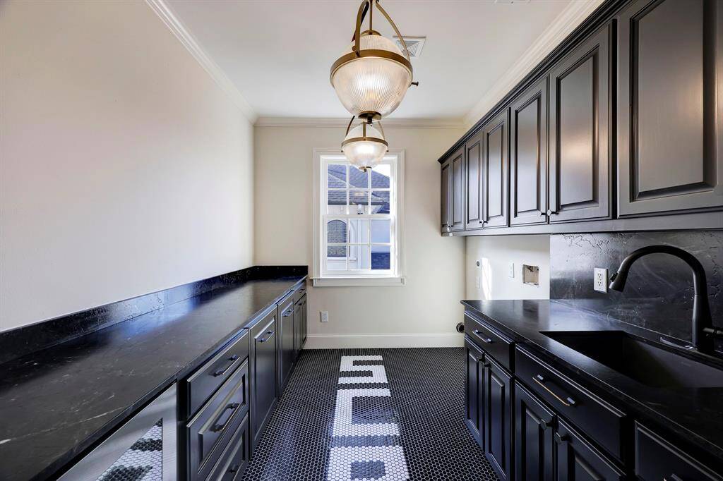 Custom laundry room with beverage fridge & built in laundry sorters.