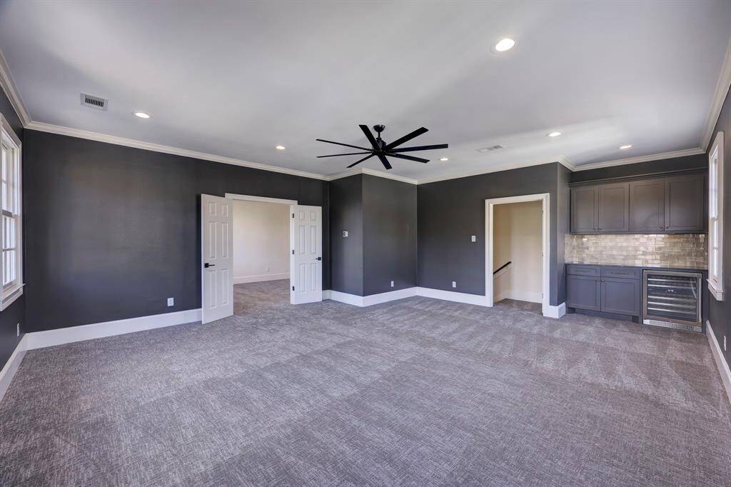 Media Room or Game Room complete with custom electric blackout shades & a dry bar with beverage refrigerator.