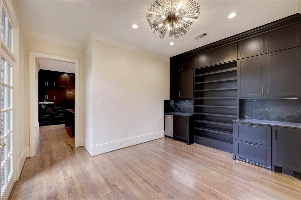 Breakfast Room adjacent to Kitchen, complete with designer lighting, built in wine storage & butlers pantry. Ice machine & double drawer pull out beverage refrigerators. Opens to courtyard garden, and leads to garage & back staircase.