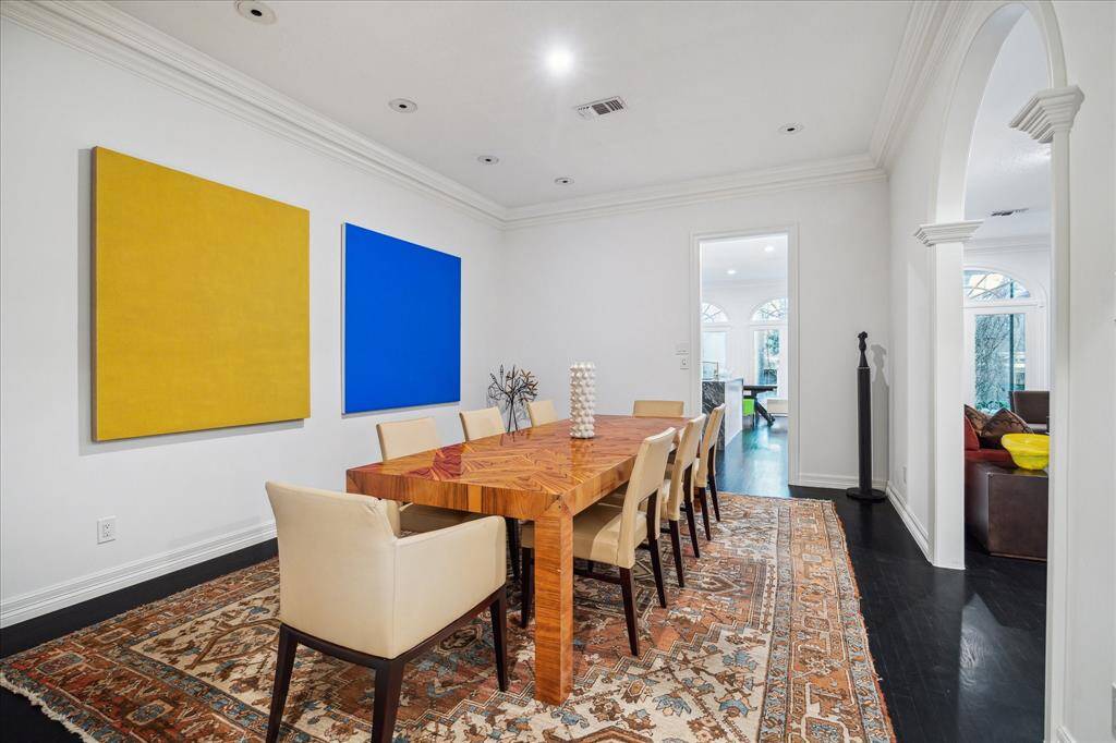 DINING ROOM - The formal dining room exudes elegance with recessed art lighting, crown molding, and seamless access to the kitchen and wet bar. Rich hardwood floors and designer neutral paint create the perfect backdrop for entertaining.