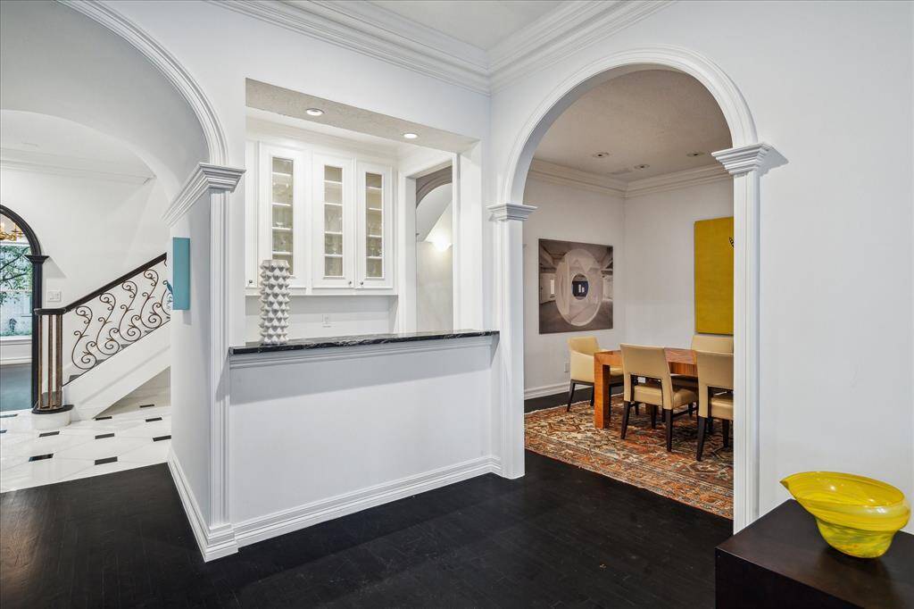 WET BAR - Thoughtfully designed, the bar seamlessly connects to the formal dining and living rooms for effortless hosting. A bar-height counter invites guests to gather in a refined yet inviting atmosphere.