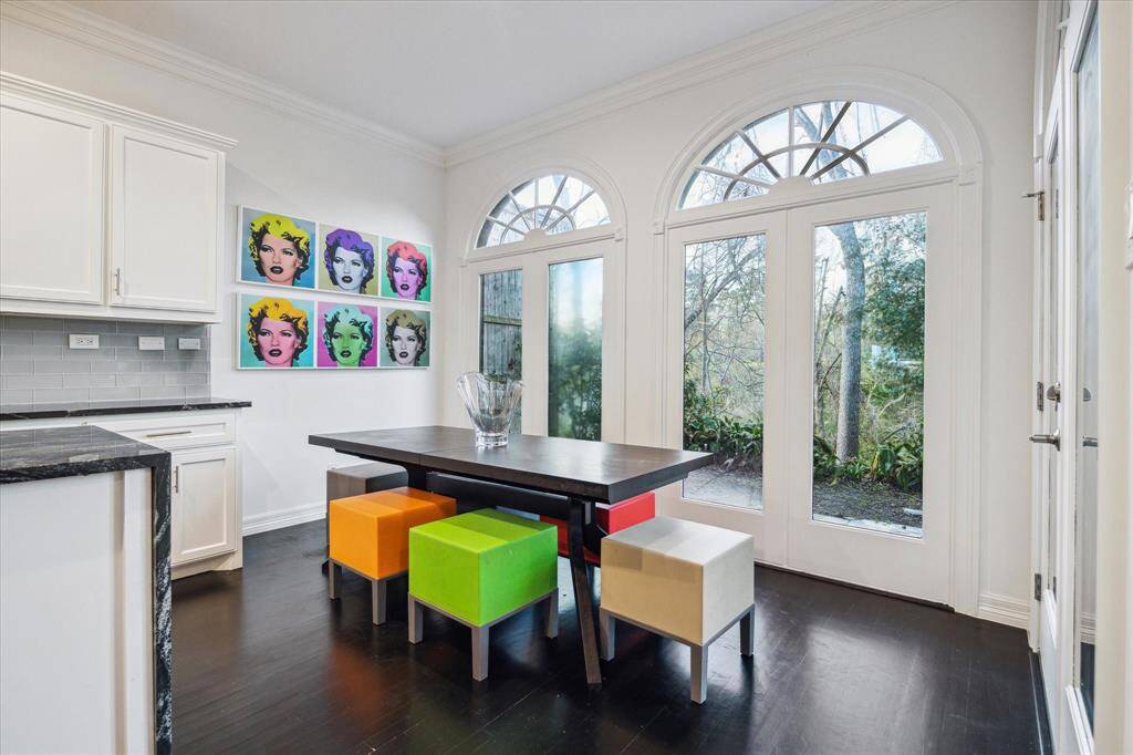 BREAKFAST ROOM - This bright and airy breakfast room features arched windows and French doors that open to the back patio. Whether enjoying morning coffee or casual meals, this space offers tranquility with a view.