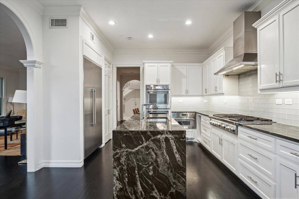 KITCHEN - Sleek subway tile, custom cabinetry, and designer brushed nickel hardware define this beautifully appointed space. The open layout allows for effortless entertaining while maintaining a highly functional design.