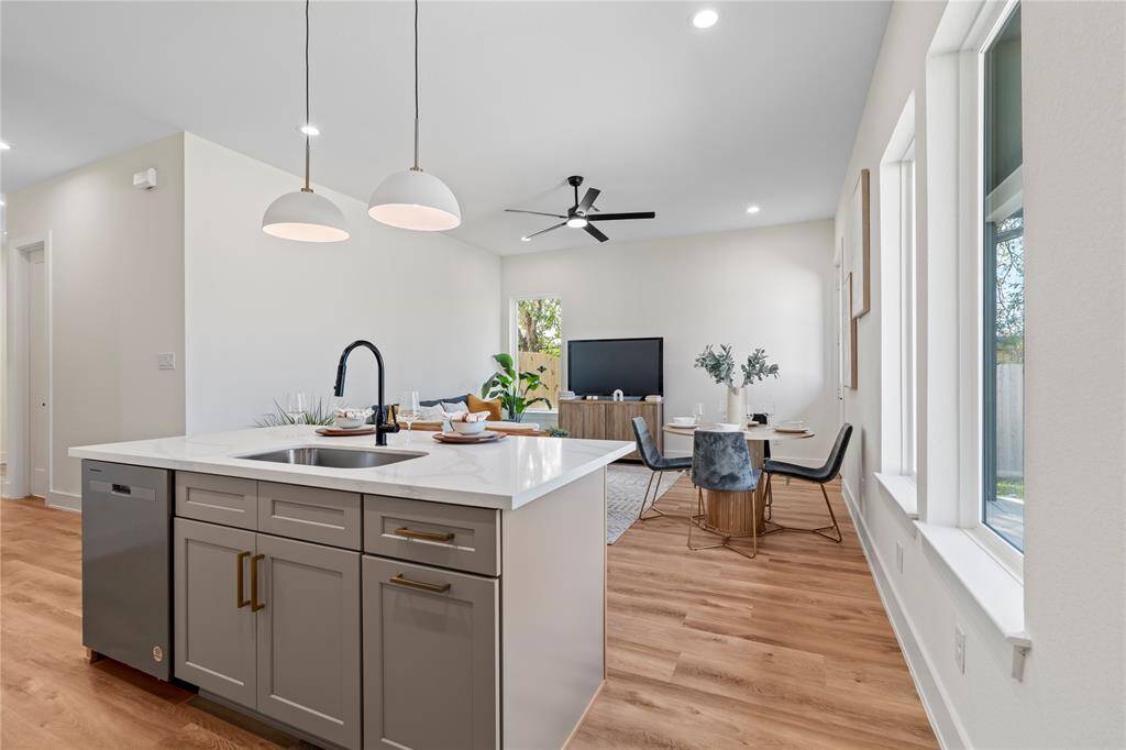 The farmhouse-style sink adds charm and practicality, overlooking the open living area for a seamless flow. Perfect for staying connected while prepping meals.