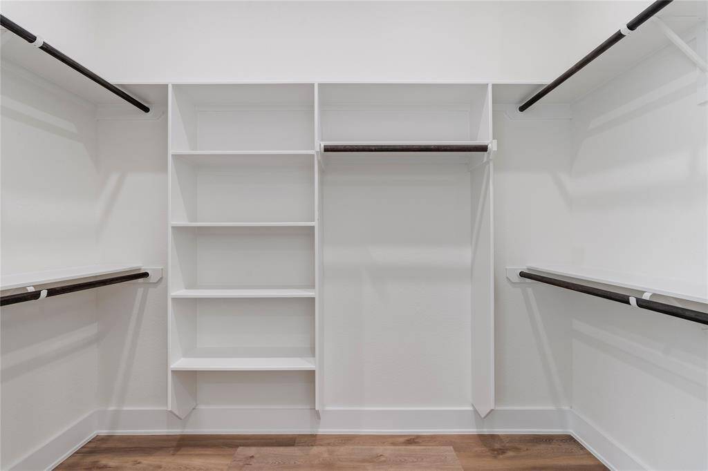 The primary closet is spacious and organized, featuring built-in shelves for optimal storage and easy access to your wardrobe