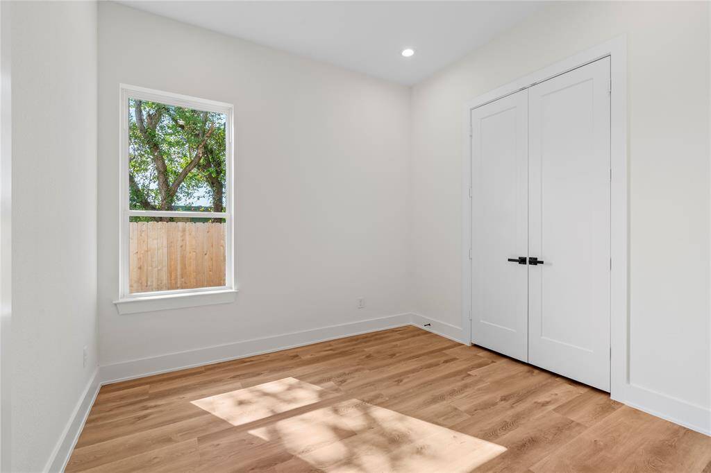 The secondary bedroom features a large window, allowing natural light to fill the space and create a bright, welcoming atmosphere