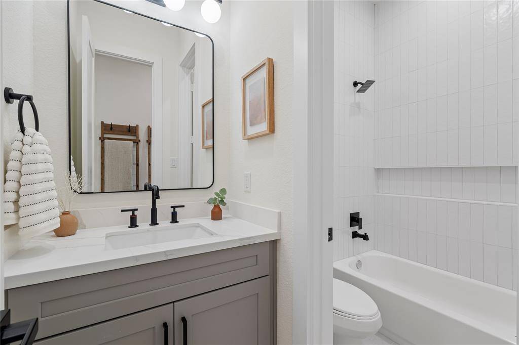 The secondary bathroom, conveniently located for the first bedroom and guests, offers a modern design and stylish finishes for ultimate comfort