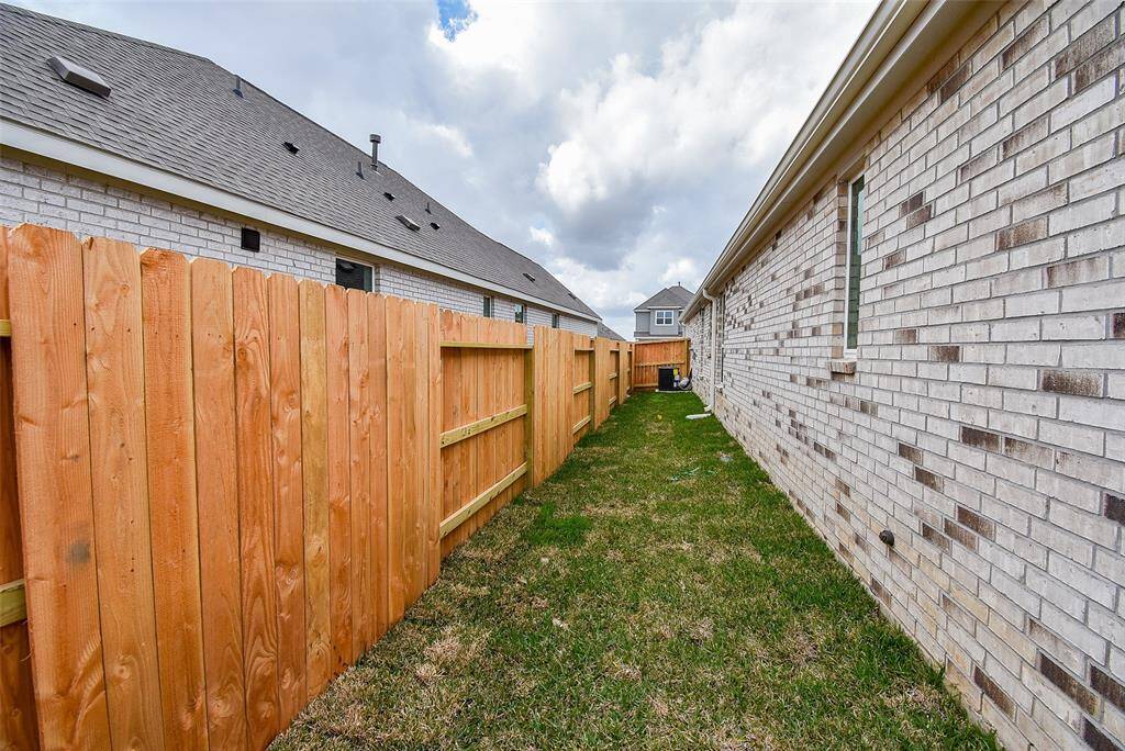 Side yard to the right of the garage.  High privacy fence and automatic sprinkler system.