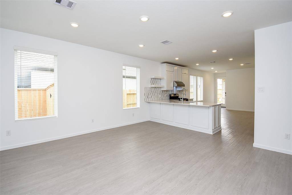 Recessed lighting and large windows make this space open and bright. (staged)